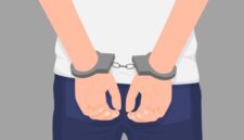 Cartoon crime man hands in handcuff at back isolated. Colorful arrested male arms wearing manacle behind vector graphic illustration. Close up law perpetrator at prison